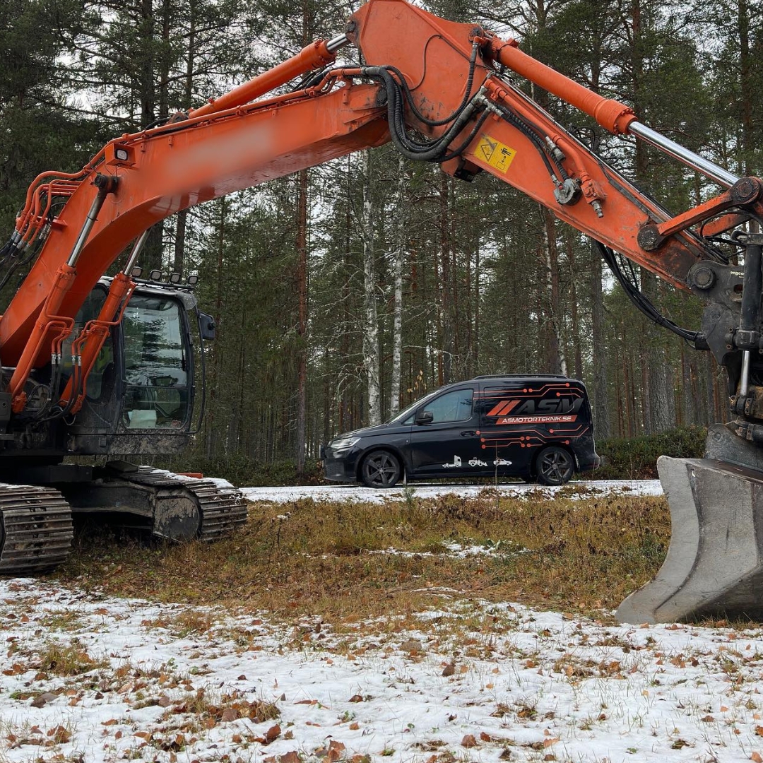 AS Motortekniks jourbil parkerad intill en aktiv grävmaskin på arbetsplats
